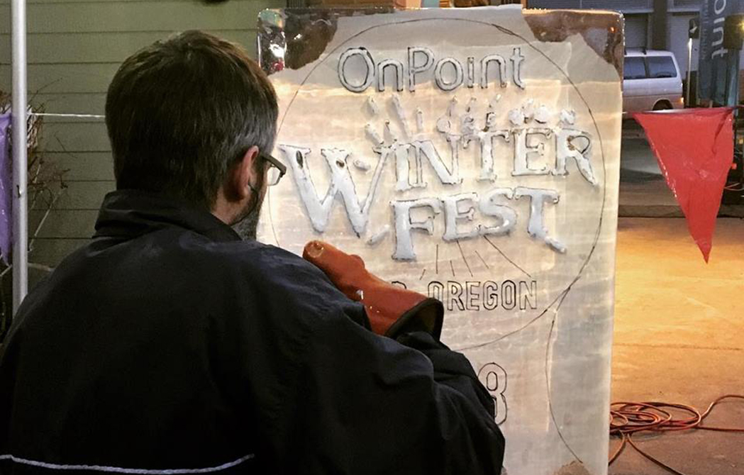 Man works on ice sculpture at First Friday event in celebration of the upcoming WinterFest event