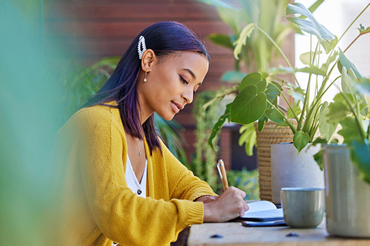 Woman writing her balances in a notebook to prepare for a system update