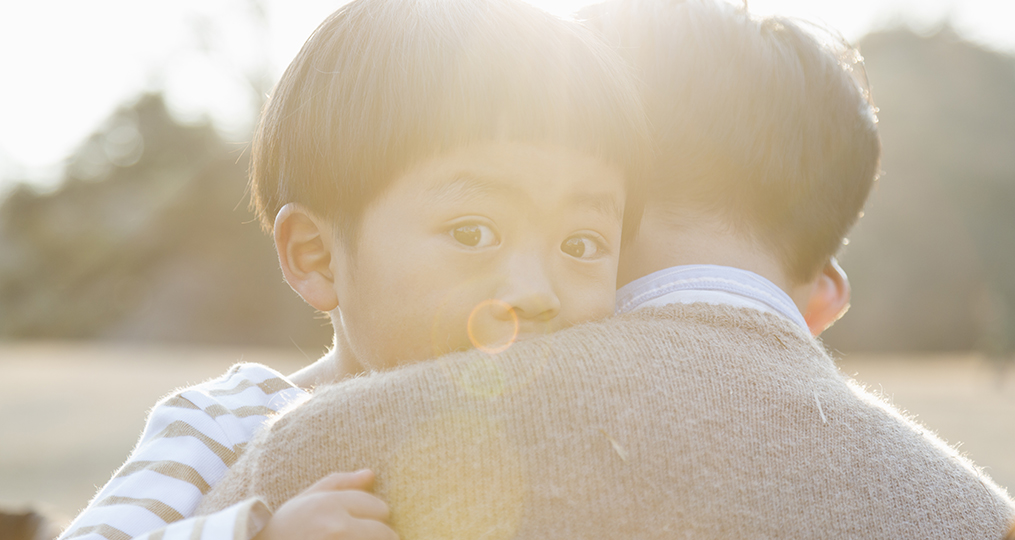 Father embracing crying son