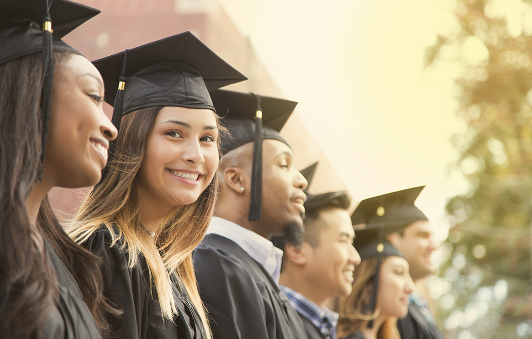 Latin descent girl waits in line during college graduation ceremony.