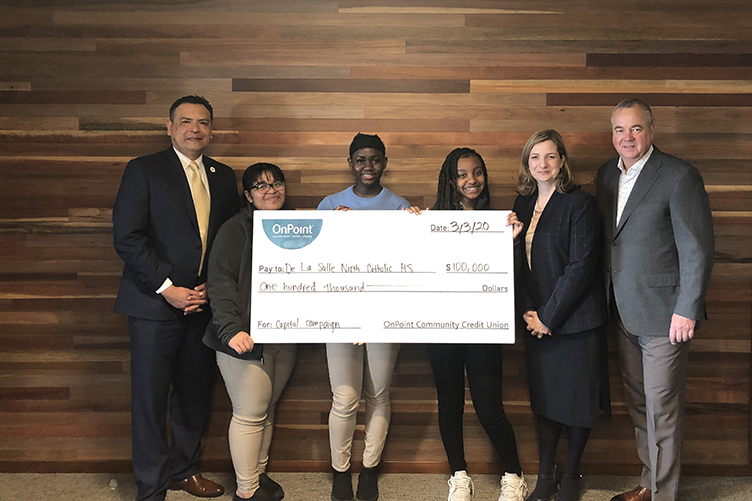 OnPoint presents display check of $100,000 to officials and students of De La Salle North Catholic High School