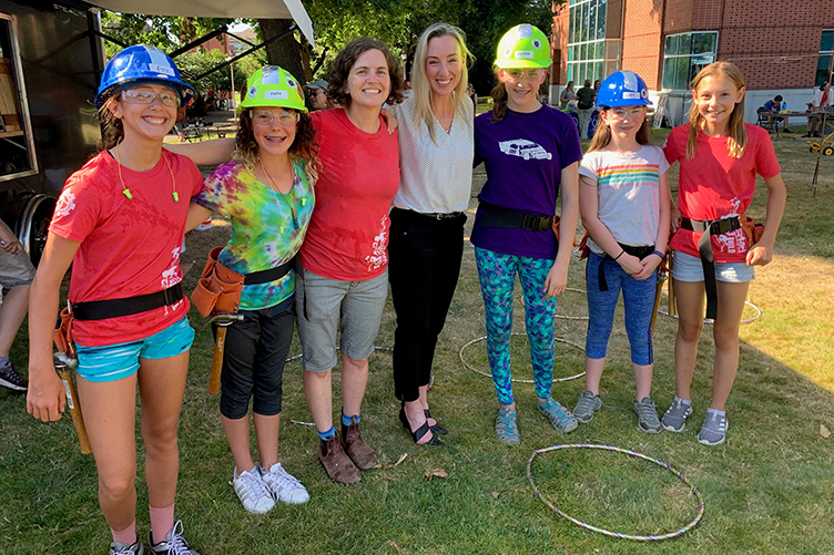 OnPoint employee with kids from Girls Build during OnPoint's Community Relations Committee check presentation