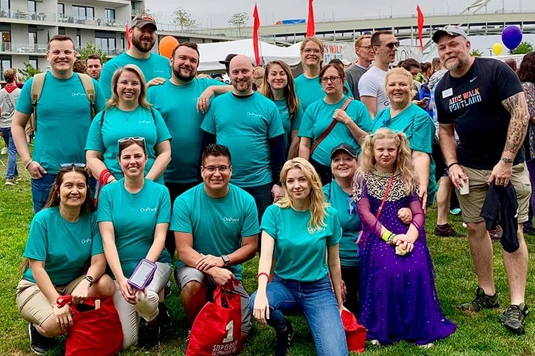 Group of OnPoint employees in their volunteer t-shirts pose at the end of volunteering at the Portland AIDS Walk.