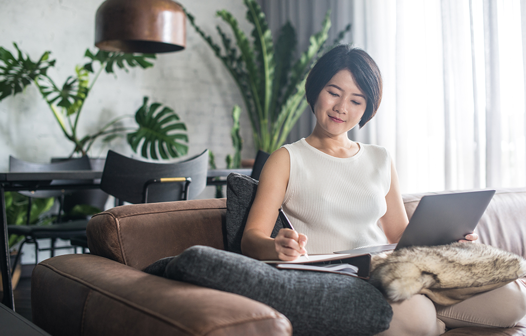 Young Asian woman using the laptop in the living room.