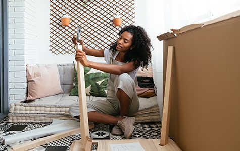 Woman in her new home putting together a small table
