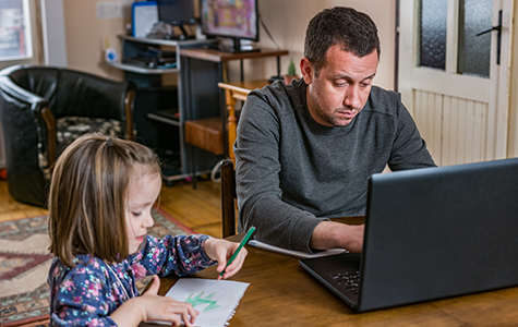 Father working from home with young child in quarantine isolation