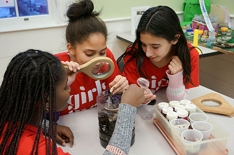 Young girls work on a science experiment as part of the Girls Inc program.