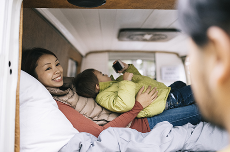 Happy family laying inside their camper van