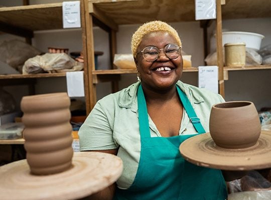 Woman holding pottery smiling onpoint business banking