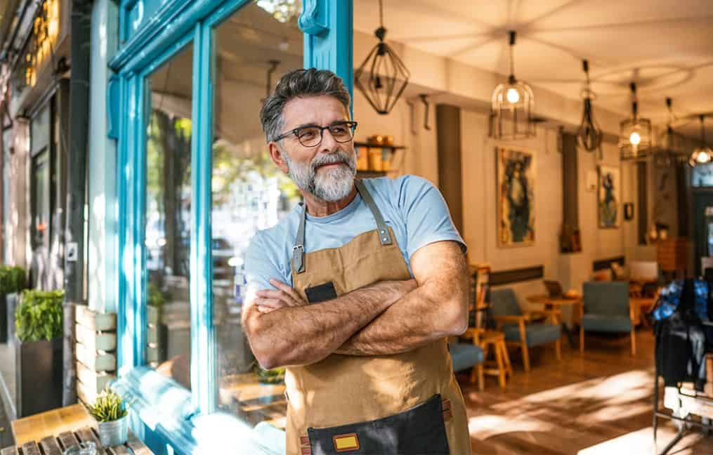 guy standing outside of his business with arms crossed