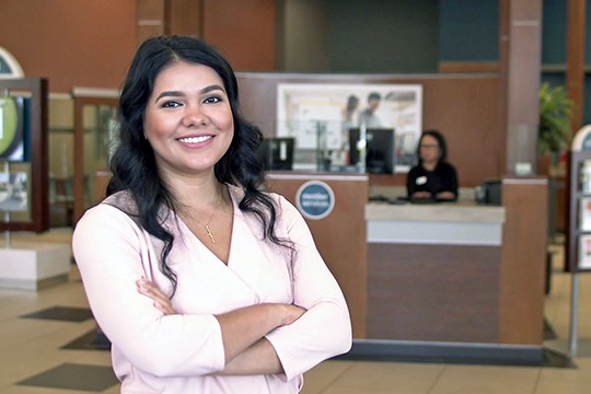 Araceli smiling in front of member services station at Beaverton Branch