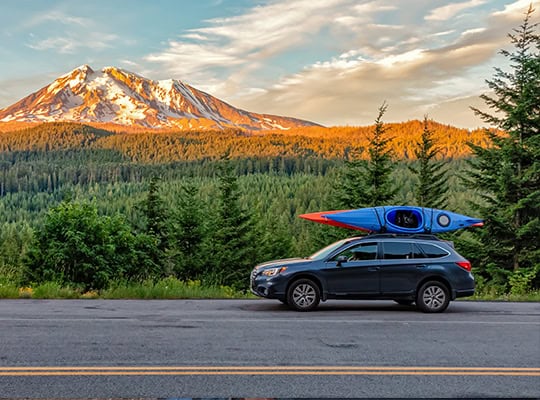 Auto financing onpoint community credit union car driving on nw mountain road with kayaks on roof