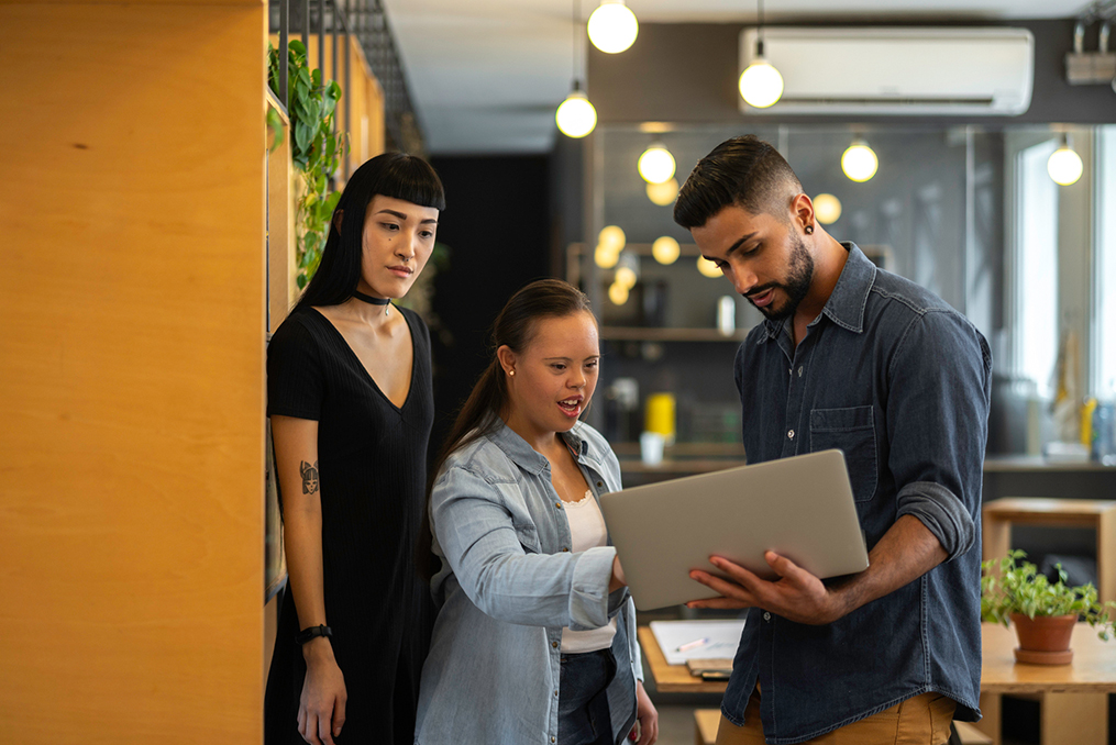 Teach employees about cybersecurity_How Small Business Owners Can Teach Their Employees About Cybersecurity_Young Man holding laptop teaching coworkers