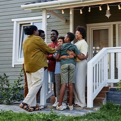 Family hugging outside of a home