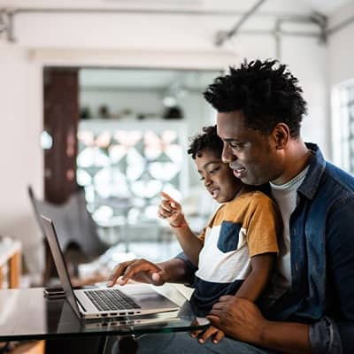 father with son looking at computer screen