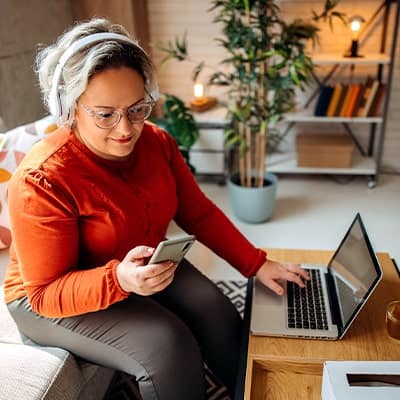 woman-looking-at-her-phone-sitting-on-couch