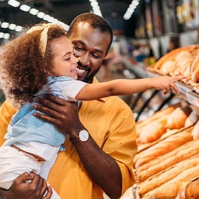 little-girl-pointing-at-bread-in-dads-arms