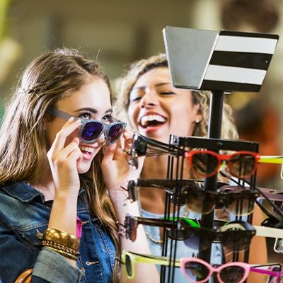 teenage-girls-trying-on-sunglasses-at-mal