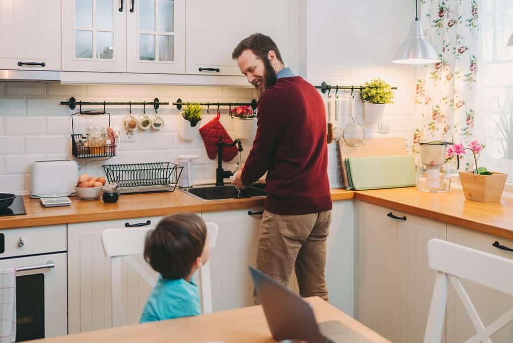 father-washing-dishes-looking-back-at-son