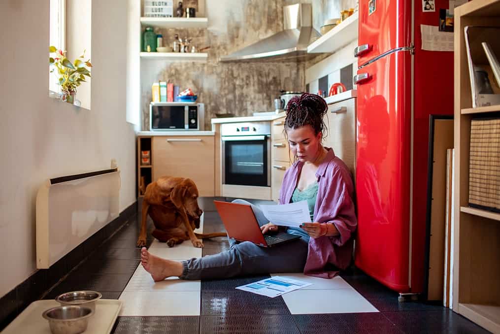 _woman-on-the-floor-looking-at-paperwork-with-dog