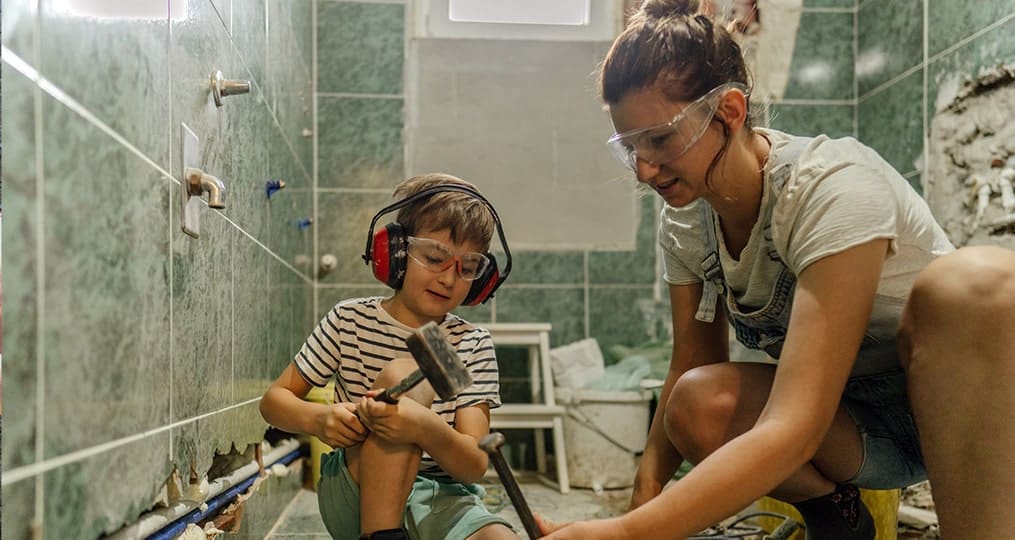 mom and son adding tile floor to the bathroom