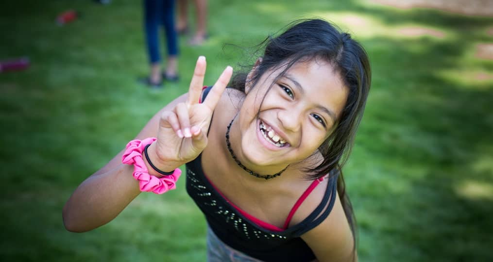 girl smiling with peace signs