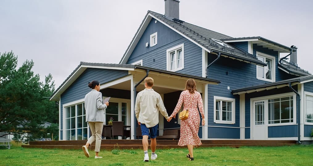 couple-looking-at-a-house-with-agent