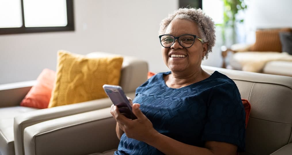 older-woman-sitting-down-looking-at-her-phone