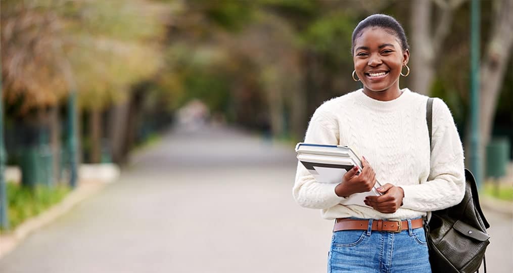 Girl standing outside with text books