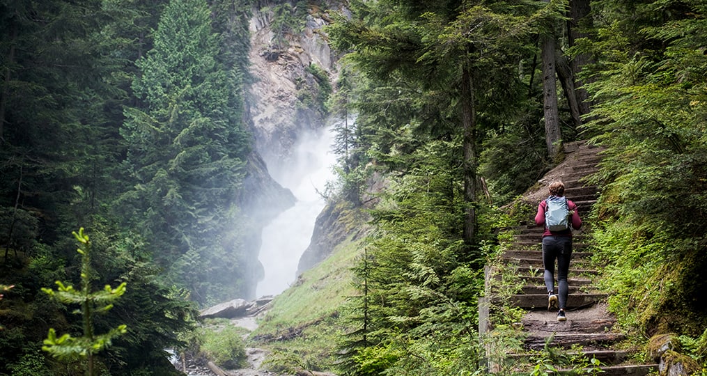 person-hiking-next-to-waterfall