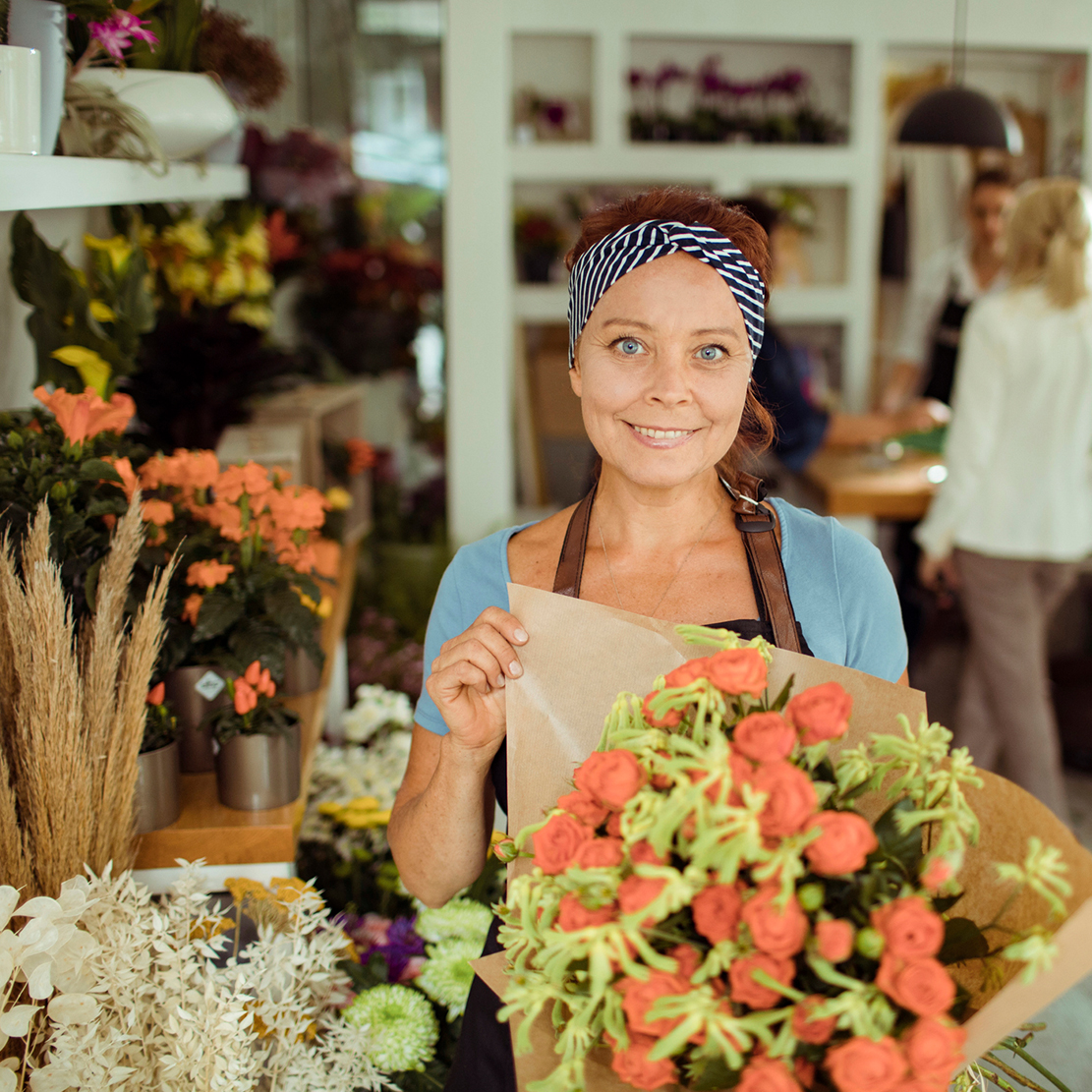 Flower Shop Owner Hero shot showcasing bouquet of flowers in her shop
