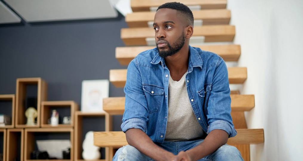 Managing Student Loan Debt during COVID-19_Concerned young man sitting on steps
