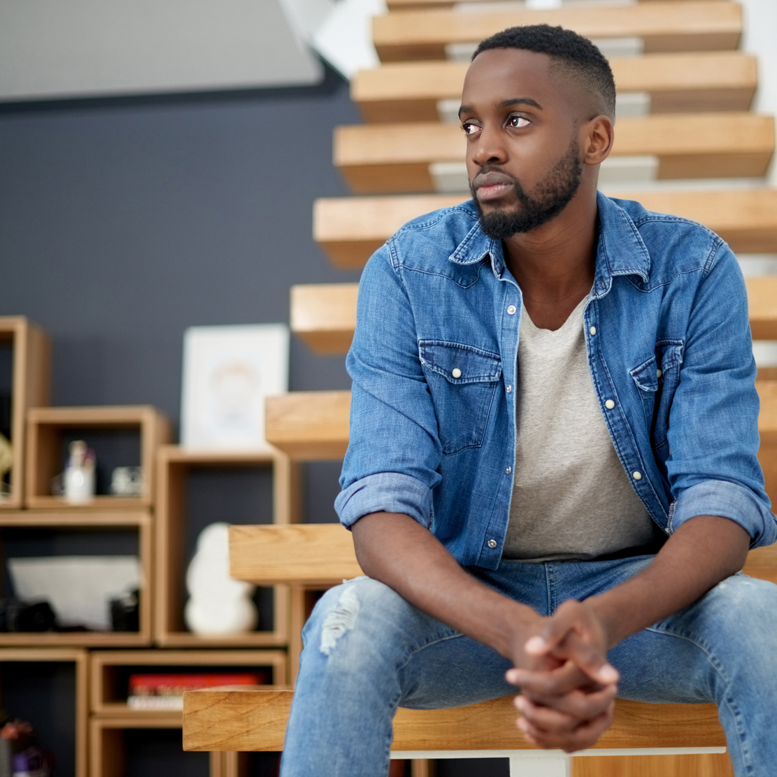 Managing Student Loan Debt during COVID-19_Concerned young man sitting on steps