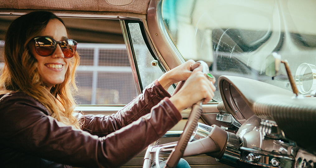 Smiling Young Woman Driving Vintage American Car_6_step_plan_for_getting_your_finances_in_order_taking_control_vintage_car