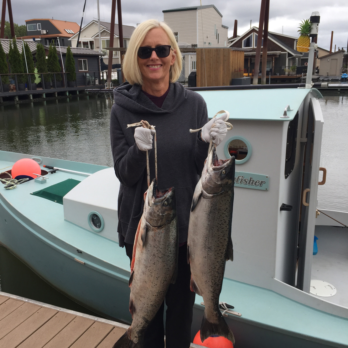 Terri Hunter employee spotlight_fishing and holding two large fish