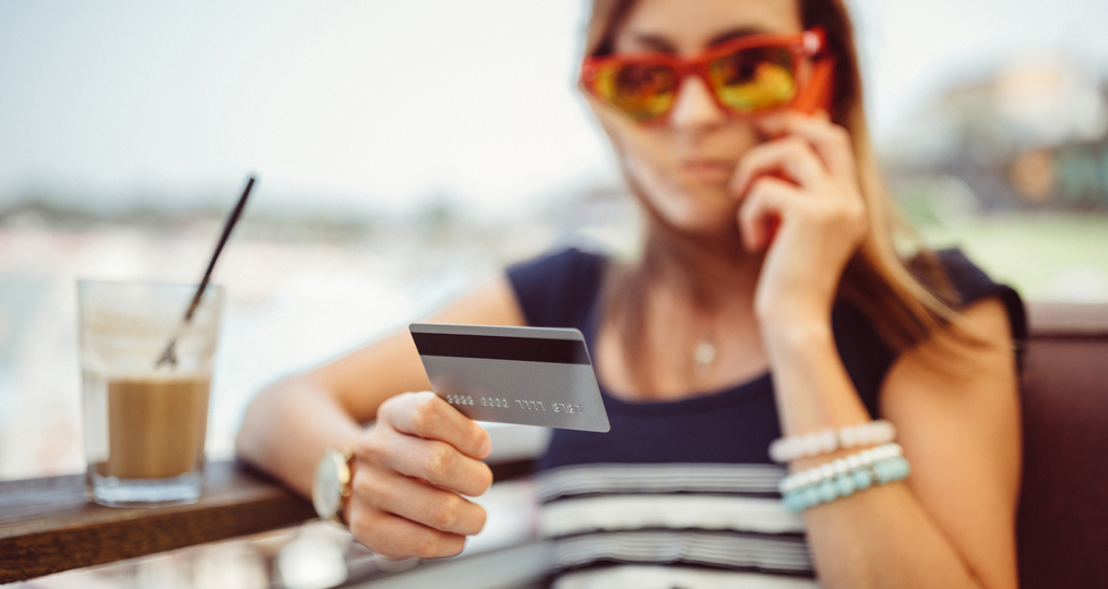 Vishing How to Protect Yourself From Phone Fraud_Woman holding her credit-debit card while talking on the phone