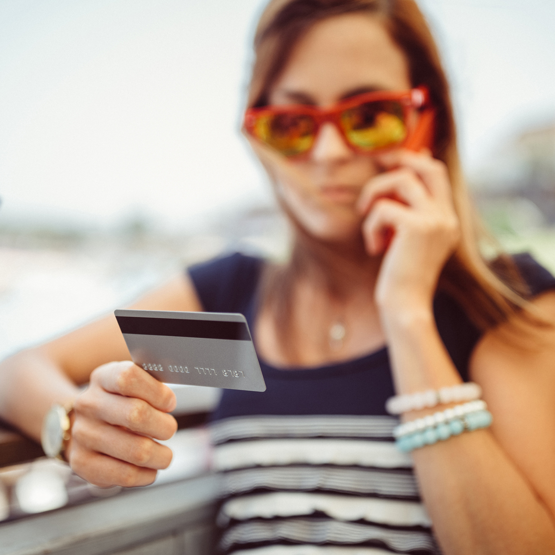 Vishing How to Protect Yourself From Phone Fraud_Woman holding her credit-debit card while talking on the phone