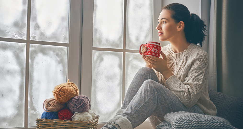 What Is a Credit Freeze and Should You Freeze Your Credit_woman sitting near her window looking out at the winter cold