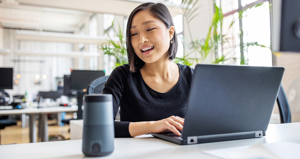 how to secure your smart speakers_professional woman giving a voice command to the smart speaker in her office