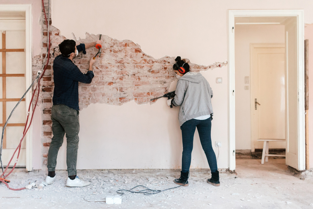 couple doing demolition on condo wall