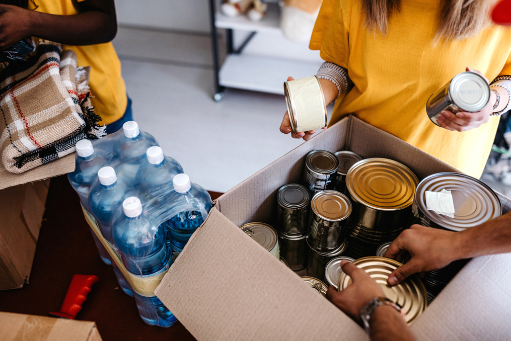 Don't Get Scammed by a Fake Charity This Giving Season_workers placing food donations into box