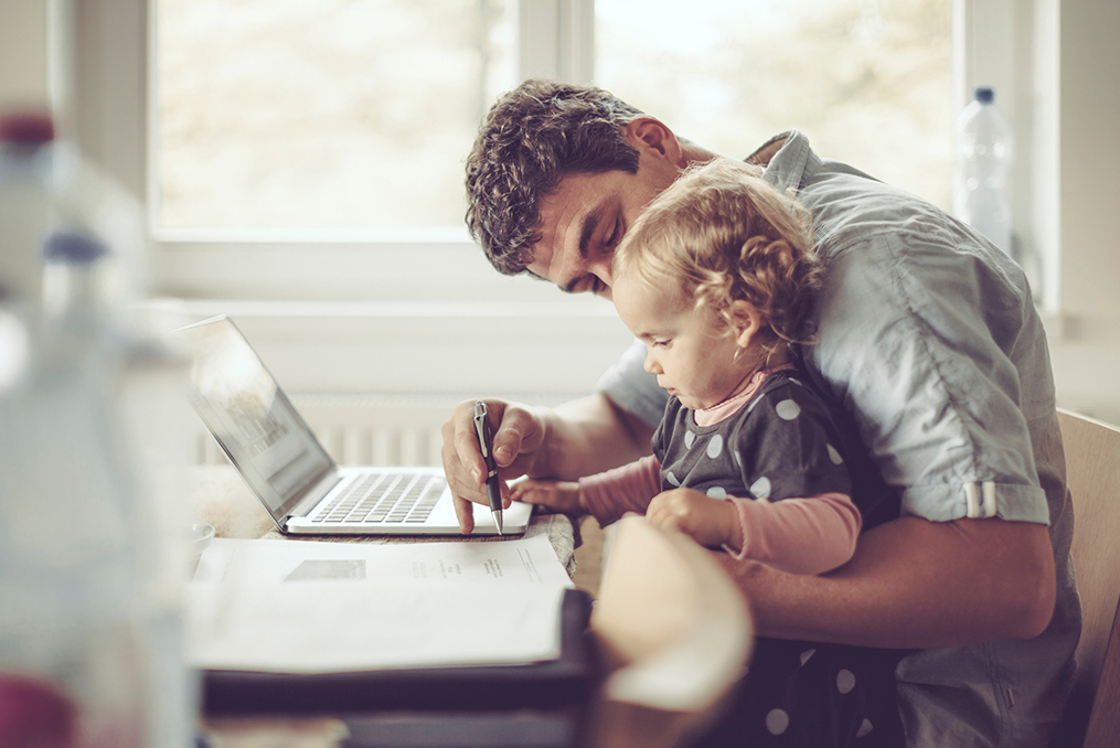 Strategies for Quitting the Paycheck-To-Paycheck Life_Father and child sitting at table working on documents