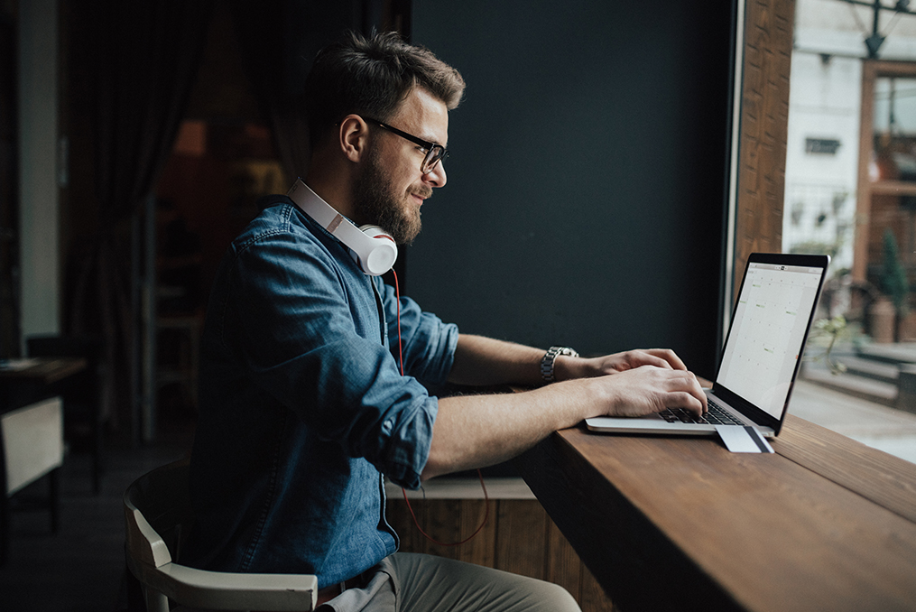 guy sitting at his computer in a coffee shop