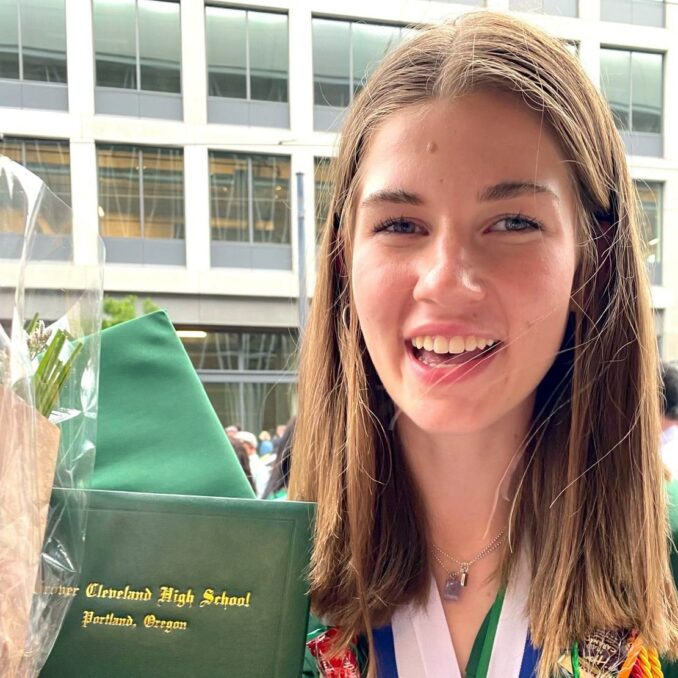 Stella Blaha holding up her diploma at graduation ceremony