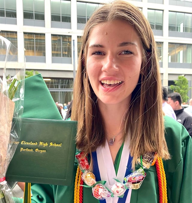 Stella Blaha holding up her diploma at graduation ceremony