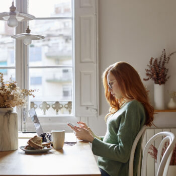 woman researching her personal accounts in her kitchen