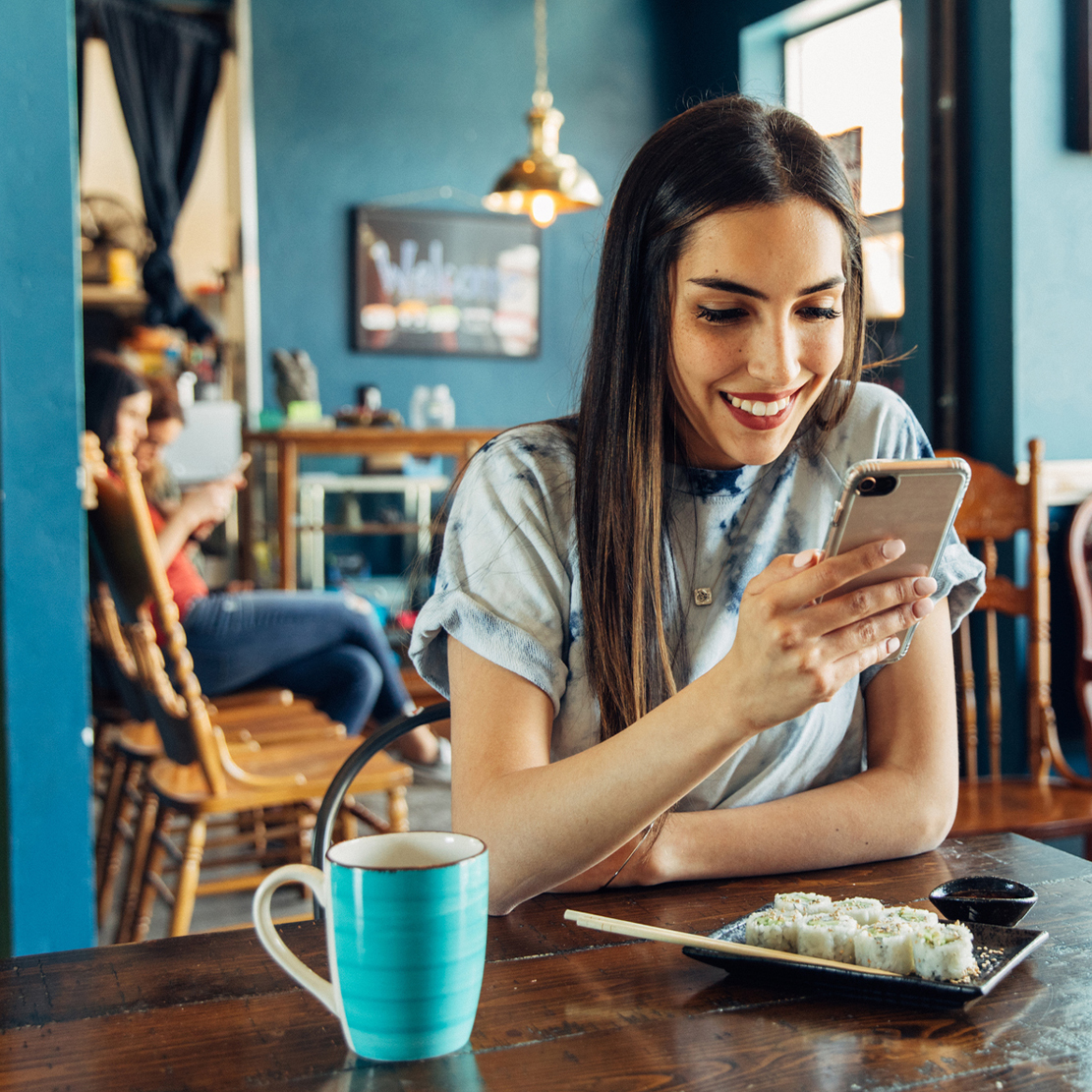 Everything You Need to Know About Popular Mobile Pay Options_woman sitting at sushi restaurant