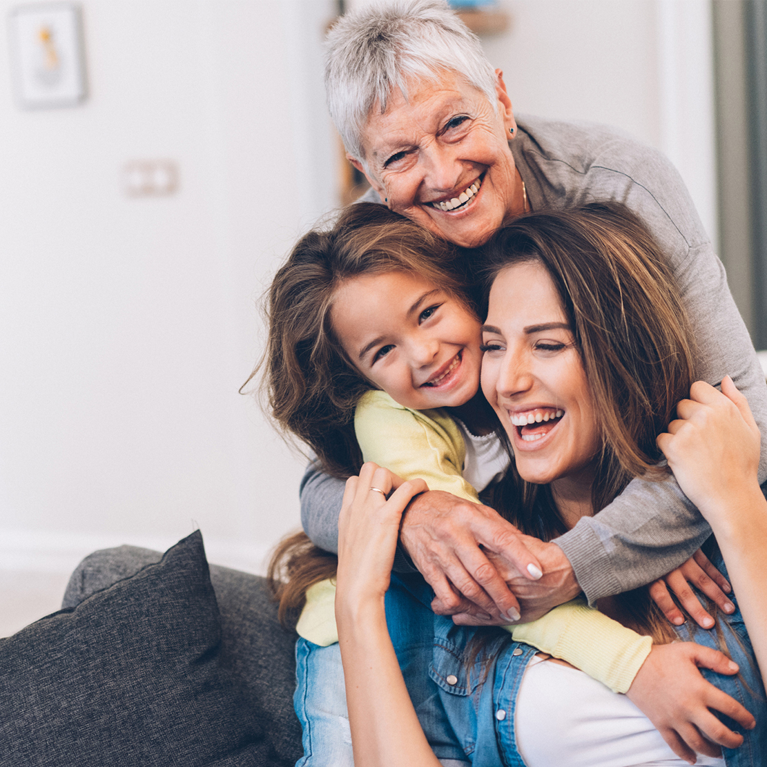 Financial Literacy Lessons for All Ages_Multi generational family sitting on couch hugging and laughing
