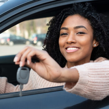 How to Spot Red Flags When Buying and Selling Vehicles_young woman holding the keys to her new car