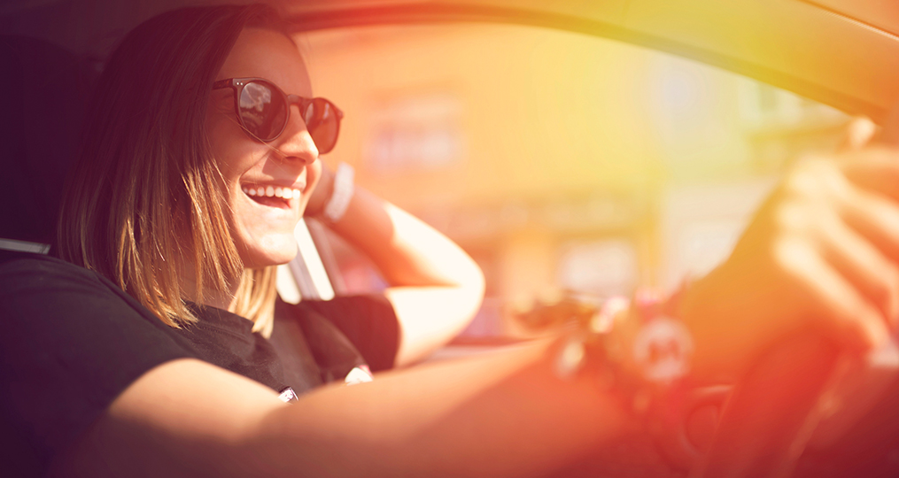 How to safely buy a used car_Young woman enjoying driving her car